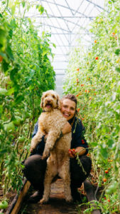 Angelika med sin hund Valle i växthuset på Angelikas gård på Österlen